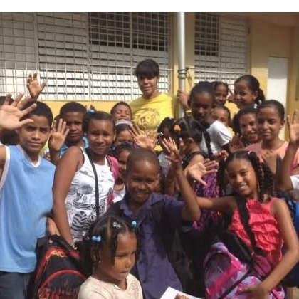 Children waving with their new backpacks at a Joy Packs distribution day
